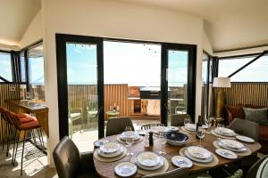 a dining room with a table with plates and wine glasses at Martello 25 in Dymchurch
