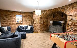 a living room with a brick wall and a foosball table at Martello 25 in Dymchurch