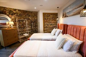 a bedroom with two beds and a mirror at Martello 25 in Dymchurch