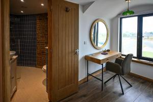 a bathroom with a wooden table and a mirror at Martello 25 in Dymchurch +34 photos