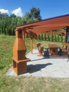 a wooden pavilion with a picnic table and a bench at Dom Wakacyjny Cztery Pory Roku in Bystra +6 photos