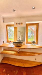 a bathroom with a sink in a room with two windows at Ferienhaus am Land in Mogersdorf