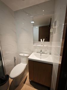 a white bathroom with a toilet and a sink at Forest City Eco Stay in Gelang Patah