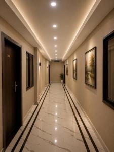 an empty hallway with paintings on the walls at Hotel Aria Bhopal Near AIIMS Hospital & Rani Kamlapati Station in Bhopal