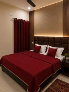a bedroom with a large bed with a red blanket at Hotel Aria Bhopal Near AIIMS Hospital & Rani Kamlapati Station in Bhopal