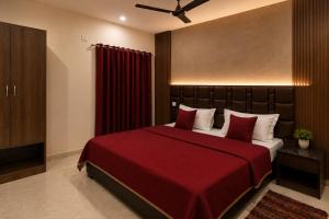 a bedroom with a large bed with a red blanket at Hotel Aria Bhopal Near AIIMS Hospital & Rani Kamlapati Station in Bhopal +18 photos