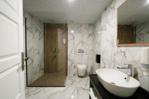 a bathroom with a shower and a sink and a toilet at Grand 464 Otel in Rize