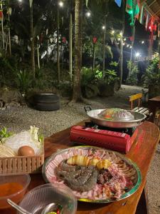 a table with a plate of food on it at Khao Phang Camping in Ban Pha Saeng Lang