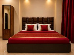 a bedroom with a large bed with red pillows at Hotel Aria Bhopal Near AIIMS Hospital & Rani Kamlapati Station in Bhopal