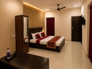 a bedroom with a bed and a desk in it at Hotel Aria Bhopal Near AIIMS Hospital & Rani Kamlapati Station in Bhopal