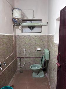 a small bathroom with a green toilet and a shower at CHIDAMBARAM Bala Residency in Chidambaram