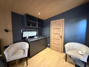 a room with two chairs and a desk and a window at U Dominicana in Kamianets-Podilskyi