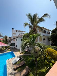 a palm tree sitting next to a swimming pool at Villa Tuffah in Watamu