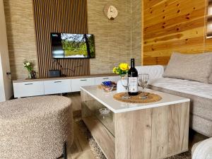 a living room with a couch and a table with wine glasses at A&A Durmitor Apartments in Žabljak