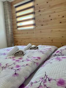 a large bed in a bedroom with a wooden wall at A&A Durmitor Apartments in Žabljak