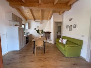 a living room with a green couch and a table at casa vacanza La Collina in Cugnana Verde