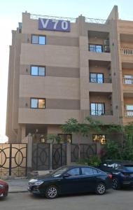 two cars parked in front of a building at Regal View Residences & Suites in Cairo