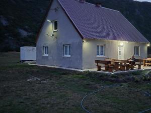 a person sitting at a table outside of a house at Komarnica Willage home in Šavnik
