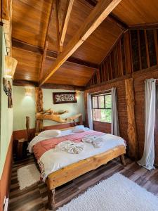 a bedroom with a bed in a log cabin at Pousada Toque de Minas in Visconde De Maua +139 photos