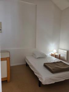 a bedroom with a bed and a table with a lamp at Camping Le Soulhol in Saint-Céré +46 photos