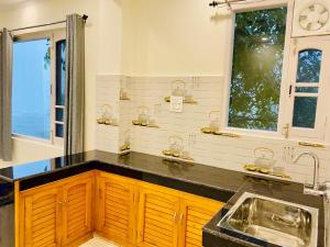 a bathroom with a sink and two windows at Jagatram Niwas Guesthouse Dharamkot in Dharamshala