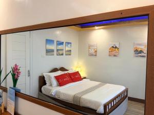 a bedroom with a large bed with red pillows at Fabregas Beach Cottages in El Nido