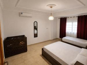 a bedroom with two beds and a dresser in it at City zen oujda in Oujda