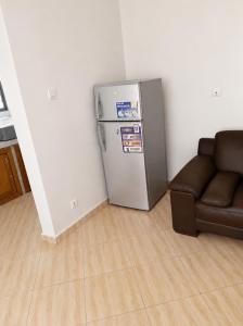 a living room with a refrigerator and a couch at Villa Daoura in Niamey