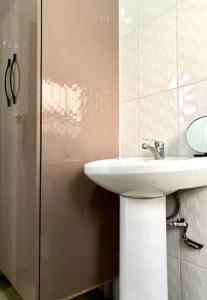 a bathroom with a white sink and a shower at SummerPlace Studio Apartments with Kitchenette in Modimolle