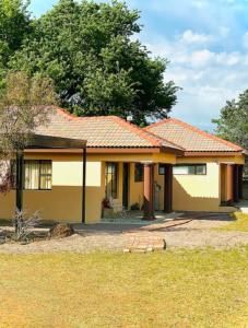 a small yellow house with an orange roof at SummerPlace Studio Apartments with Kitchenette in Modimolle