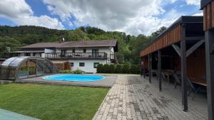 a backyard with a swimming pool and a house at CHATA POD HORAMA in Benecko