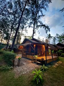 a cabin in the woods with a thatch roof at Eco Lanta Hideaway Beach Resort in Ko Lanta