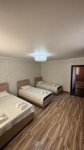 a room with three beds and a chandelier at Rinat Guest House in Pokrovka
