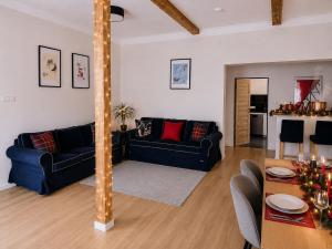 a living room with two blue couches and a table at CHATA POD HORAMA in Benecko