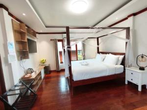 a bedroom with a canopy bed and a wooden floor at HR Resort in Ban Dong Bang