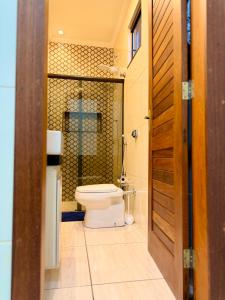 a bathroom with a toilet and a glass door at Apartamento Prates - Próx a BR 040 in Sete Lagoas +24 photos