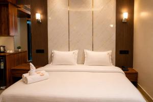 a bedroom with two beds with white pillows at Hotel Uasa Kesari Premium in Jājpur