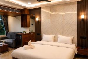 a hotel room with two beds and a chair at Hotel Uasa Kesari Premium in Jājpur