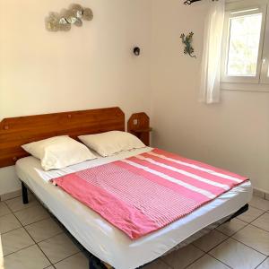 a bedroom with a bed with a pink and white blanket at auxcheneslieges in Lecci