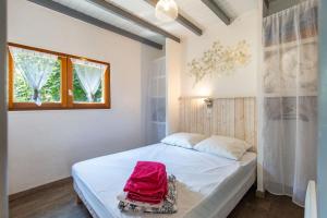 a bedroom with a white bed and a window at Gîte de groupe Le Domaine - 26 personnes au coeur des Pyrénées l Ô Domaine de Geu in Geu
