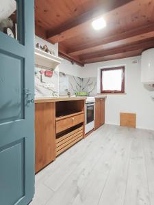 a large kitchen with wooden cabinets and a window at počitniška hiška MEDVEJKE in Slap ob Idrijci