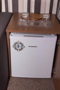 a cabinet with two glasses on top of a refrigerator at Hotel Magurele in Măgurele