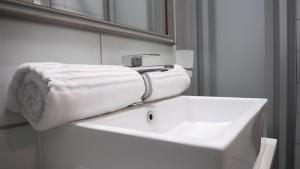 a bathroom with a white sink and a towel at Apartment Next to Hotel in Pretoria +43 photos