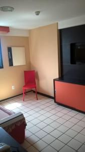 uma cadeira vermelha sentada no canto de uma sala em Boa Viagem Flat BVF 777 no Recife