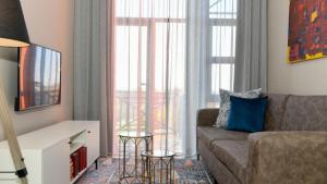 a living room with a couch and a large window at Apartment Next to Hotel in Pretoria