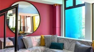 a living room with a couch and a mirror at Apartment Next to Hotel in Pretoria