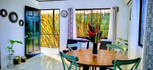 a dining room with a wooden table and green chairs at Casa Emma Quepos in Quepos