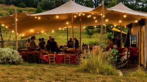 a group of people sitting under a tent with lights at Igloo, Lodge et Tipi confortable in L Honor De Cos