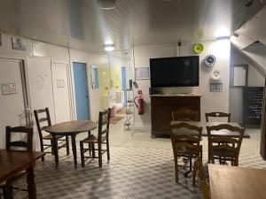 a dining room with a table and chairs and a tv at Igloo, Lodge et Tipi confortable in L Honor De Cos