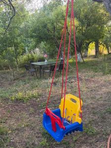a swing in a park with a picnic table at Antarut Garden House in Antarut +9 photos